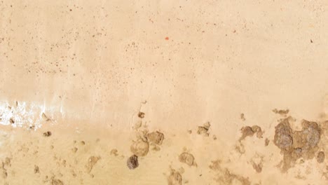 Aerial-tilt-up-and-dolly-backwards-shot-of-tropical-beach-revealing-tropical-island