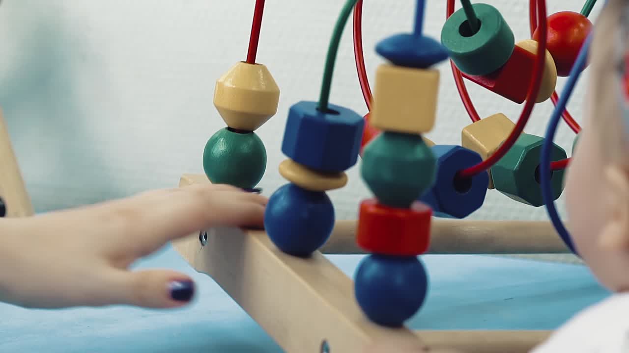 Child plays with a multi-colored toy 10