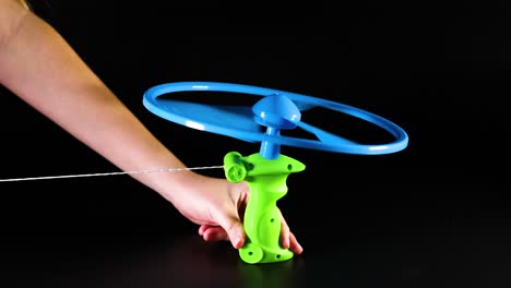 hand pulling string to launch flying toy