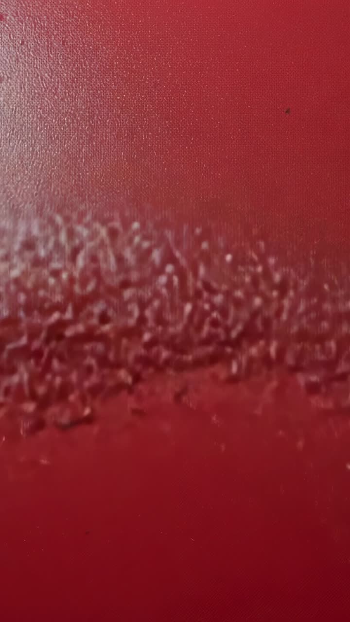 Video verticale: camera che si sposta rivelando un primo piano di un pannello rosso per mostrare la texture, esponendo una striscia con cuciture