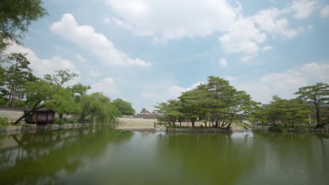 beautiful artificial pond with green trees on islets surrounding gyeonghoeru pavilion at gyeongbokgung palace on