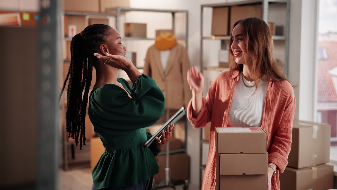 Duas Mulheres Diversas Dando High-Five em Armazém de Pequenas Empresas