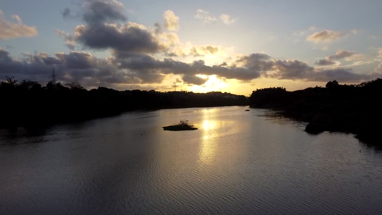 Uma tomada dolly feita com drone ao pôr do sol em um lago na República Dominicana.