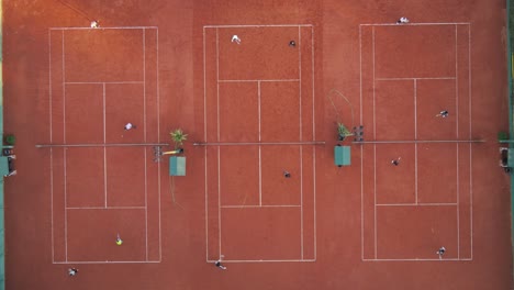 aerial top down time lapse of tennis players playing game on several courts during sunny day