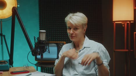 female podcast host talking in mic on camera in audio recording studio