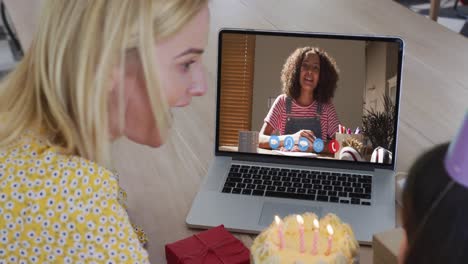madre y hija caucásicas celebrando su cumpleaños en video llamada en computadora portátil en casa
