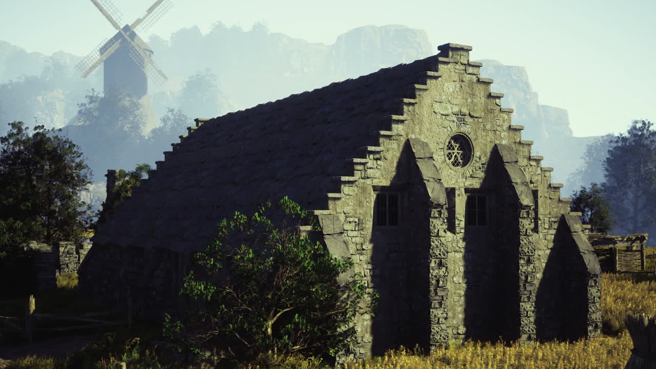 Historic stone structure by a windmill in a serene natural setting