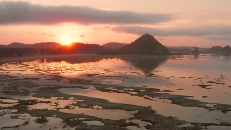 The-dry-reef-of-Kuta-Lombok-during-sunrise,-with-local-people-looking-for-food-and-seashells