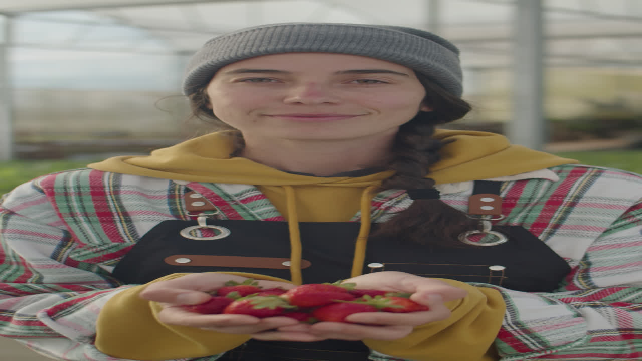 Portrait of Happy Woman Holding Handful of Strawberry in Greenhouse