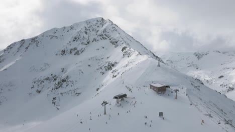 panning slowmotion panoramic drone shot of the top lift, and people skiing in the bansko ski resort