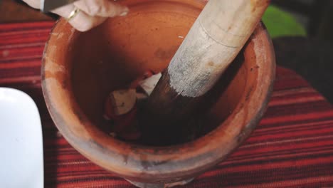 cooking som tam series: slow motion, street food vendor cutting vietnamese pork sausage and putting in mortar to make som tam or thai spicy green papaya salad, one of thailand's most popular dishes