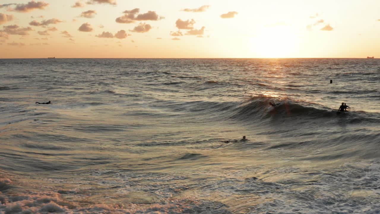 surfistas frente a la ciudad turística domburg en los países bajos durante la puesta de sol