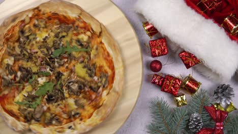 flat lay of pizza spinning 360 degree rotation on wooden salver, christmas decorations around.