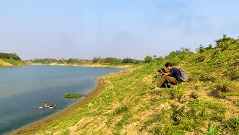 un fotógrafo de la naturaleza capturando patos nadando juntos en el río surma