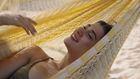 garota de verão desfrutando de uma hamaca verticalmente em close-up. mulher feliz sonhando praia de descanso