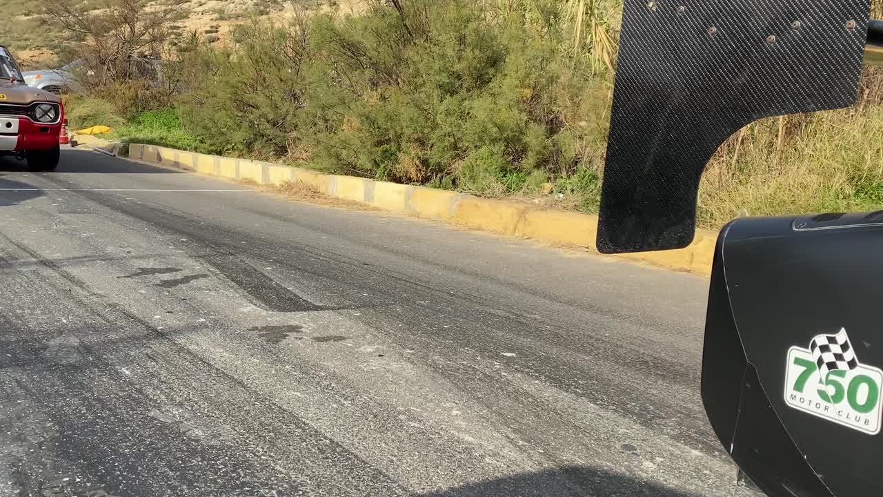 Black Race Car Slowly Passing Through Before A Race On The Hill In Malta - close up shot