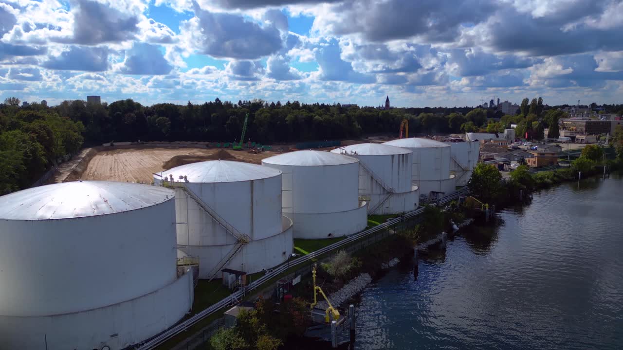 Decommissioning of Storage depot for petroleum products storage silos and containers. Industrial storage tanks holding oil and gas products. Smooth aerial view flight ascending drone