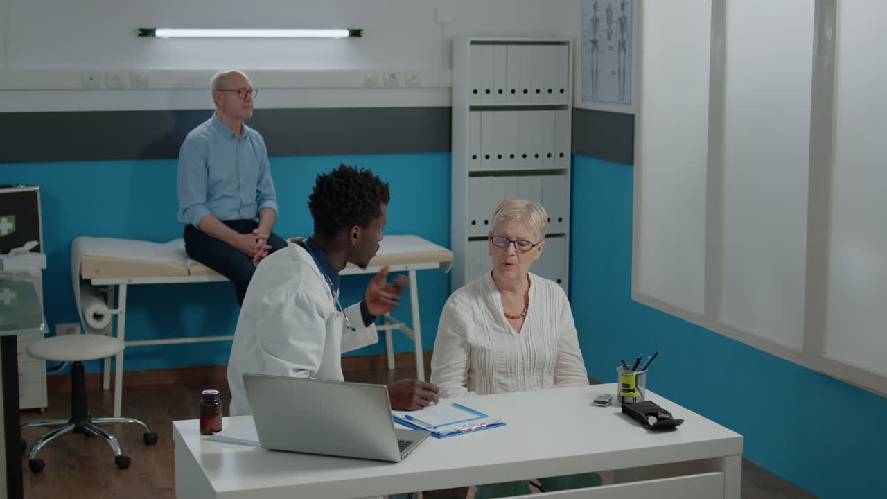 Young medic consulting sick elderly woman with disease