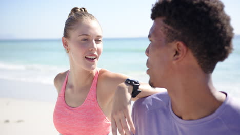 young caucasian woman and biracial man share a joyful moment on a sunny beach