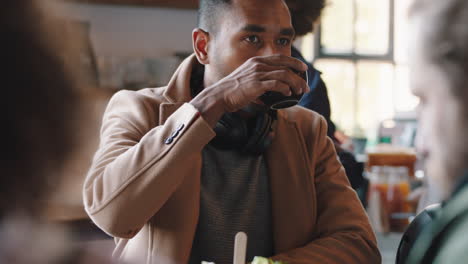 young businessman drinking coffee in cafe enjoying relaxing on lunch