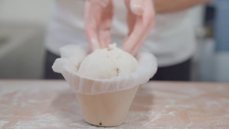 Bread-loaf-forming-process-in-the-bakery,-closeup-on-baker's-hands