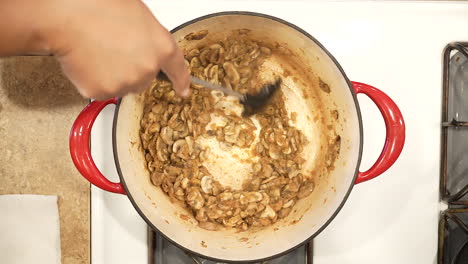 sautéing organic mushrooms in a pot on the stove in preparation for making soup - overhead view wild rice series