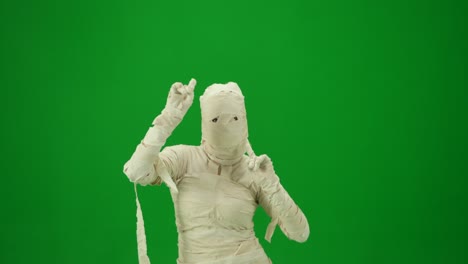 scary mummy wrapped in bandages dances wearing a black hat and sunglasses green screen isolated