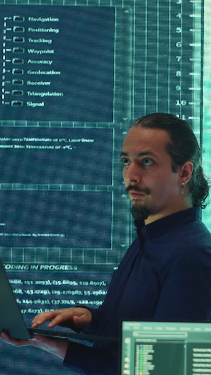 Male Developer Typing on Laptop in Futuristic Server Room