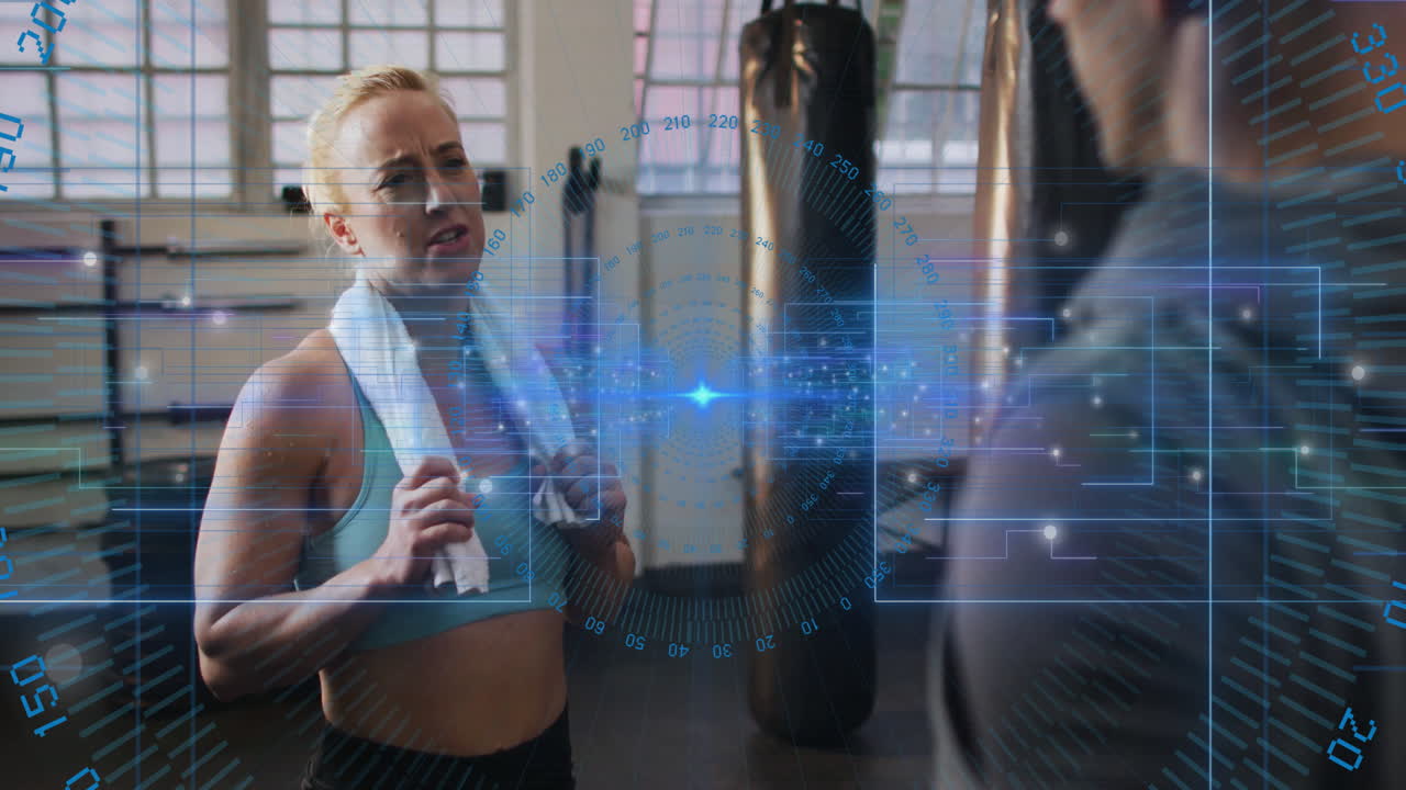 Woman holding towel in gym with digital interface overlay animation