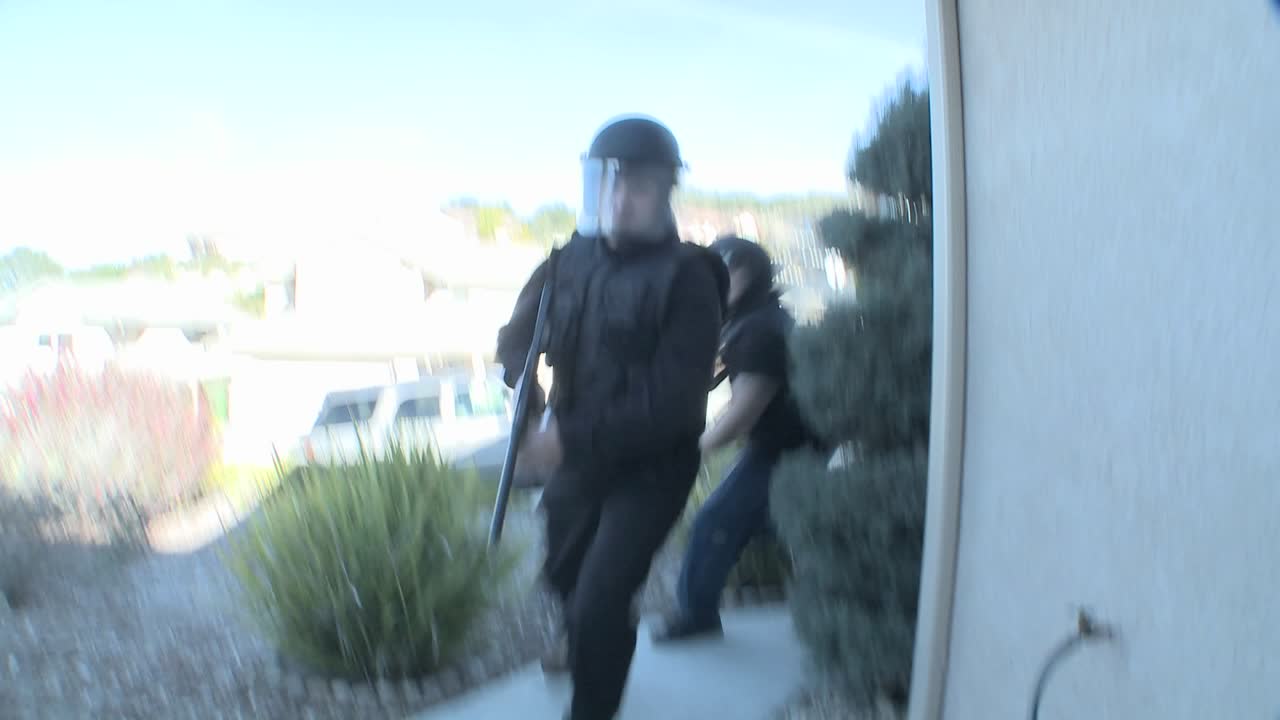 持有槍支的dea官員在一家房屋進行毒品突襲