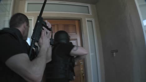 oficiales de la dea con los brazos en alto realizan un allanamiento de drogas en una casa