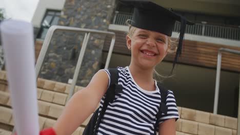 video of happy caucasian girl wearing graduation hat and holding diploma