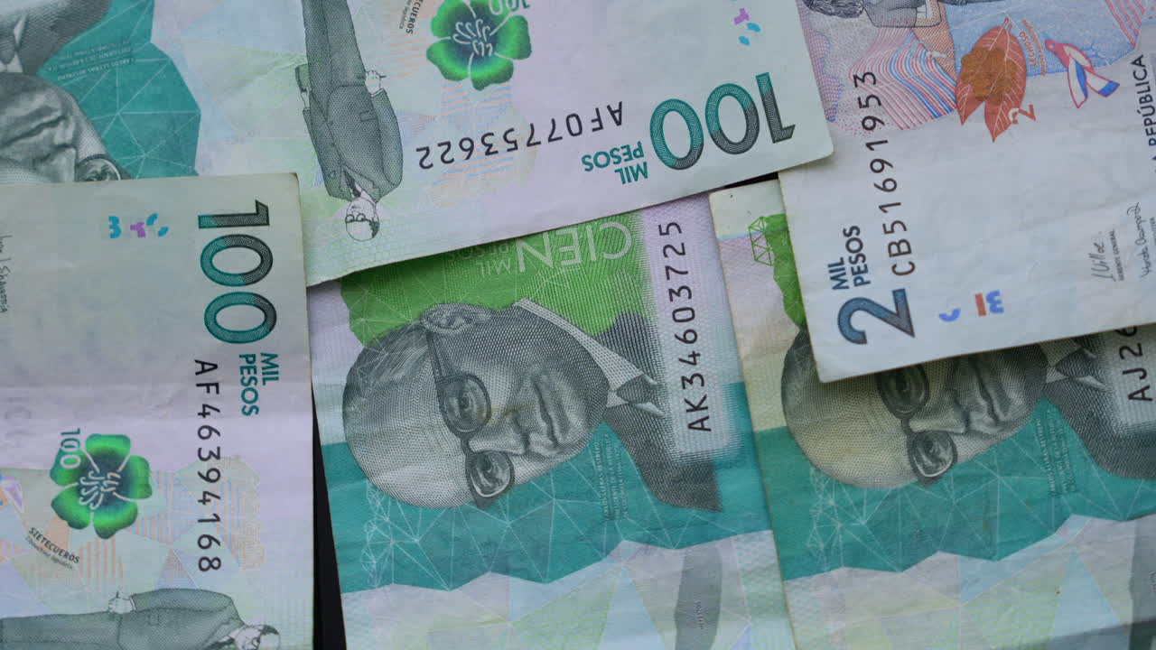 Detailed macro close-up of Colombian pesos banknotes showcasing vibrant currency designs and denominations under soft lighting. Ideal for financial and economic content, emphasizing texture