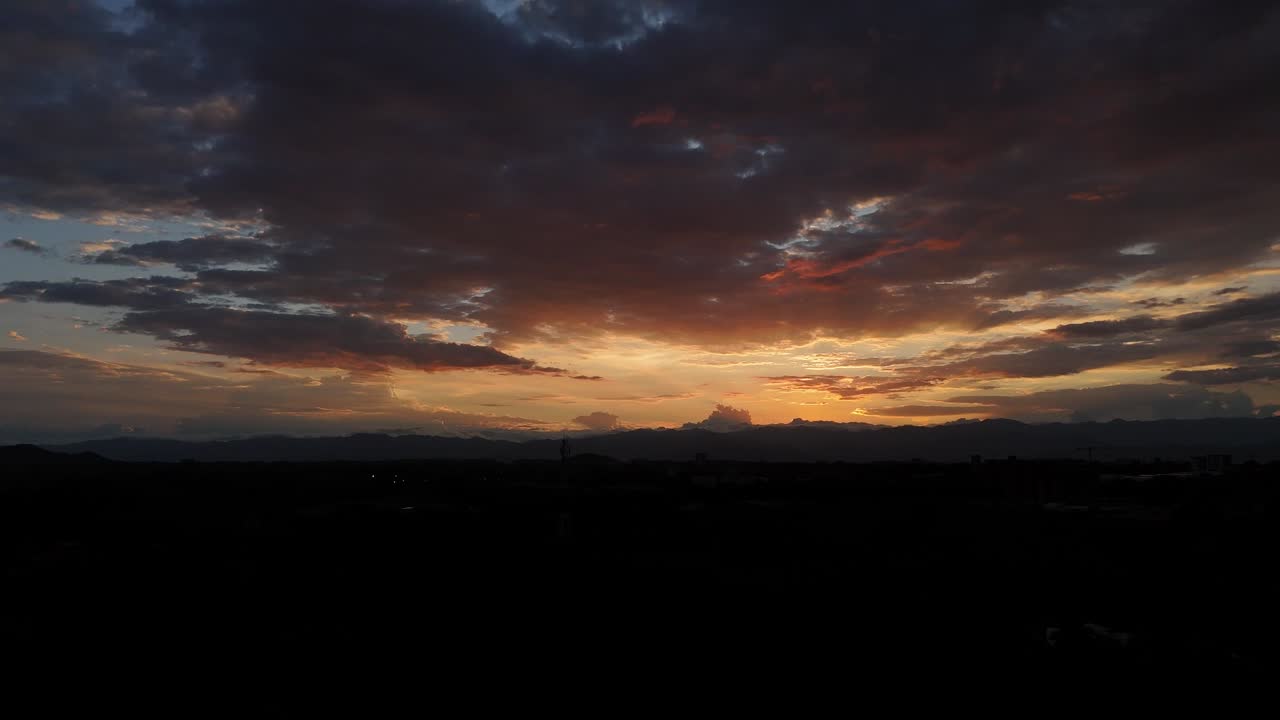 Sunset over tropical cityscape with palm silhouettes