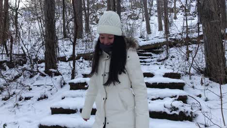 Tired-woman-climbing-down-snowy-stairs-in-the-mountain