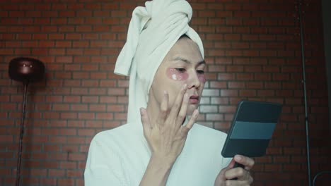 woman applying eye masks and makeup