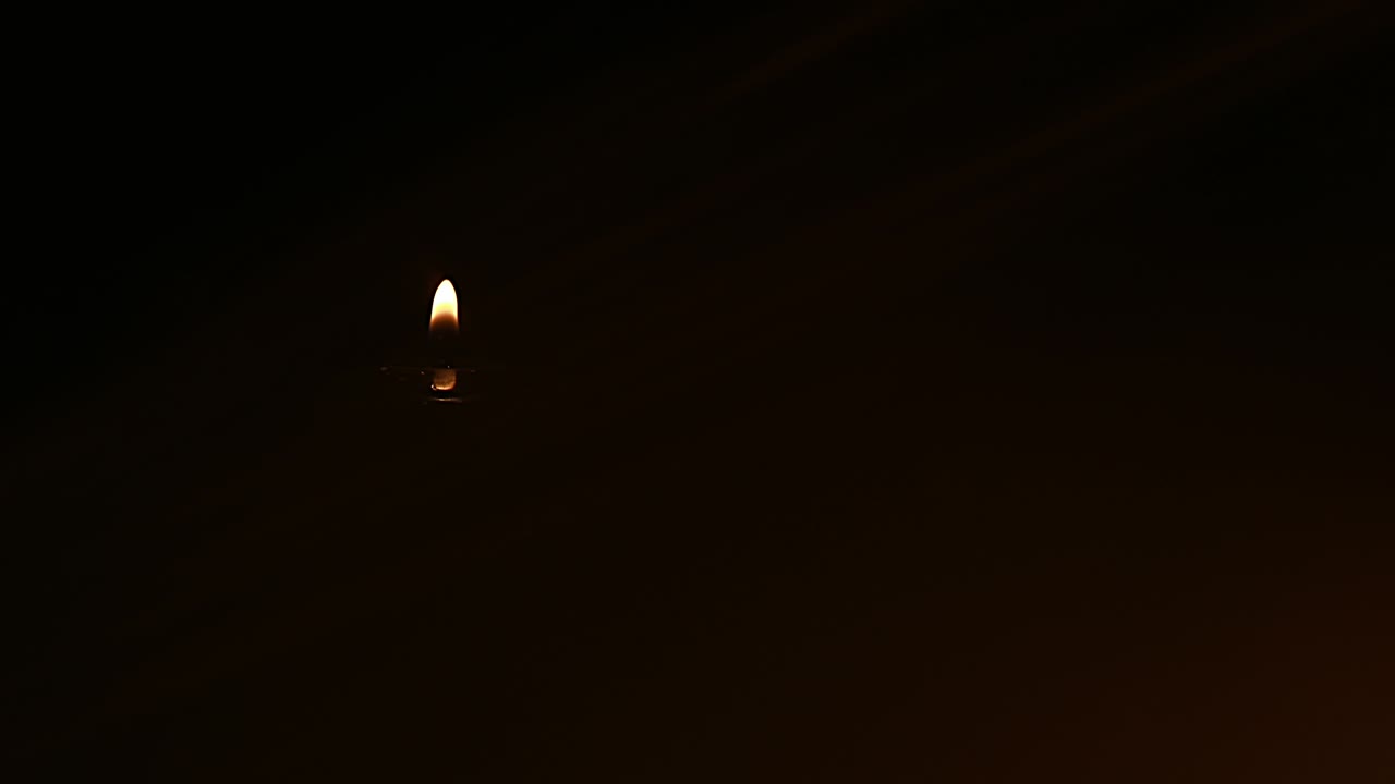 burning black candle close up swirls on a black background. selective focus.