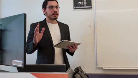 presenter gesturing while explaining with tablet