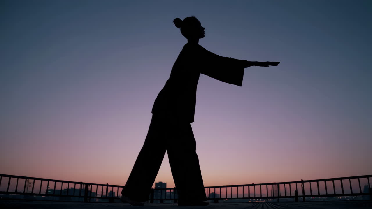 Woman practicing Tai Chi at sunset