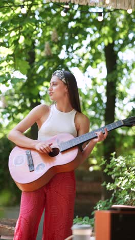 young woman playing guitar outdoors