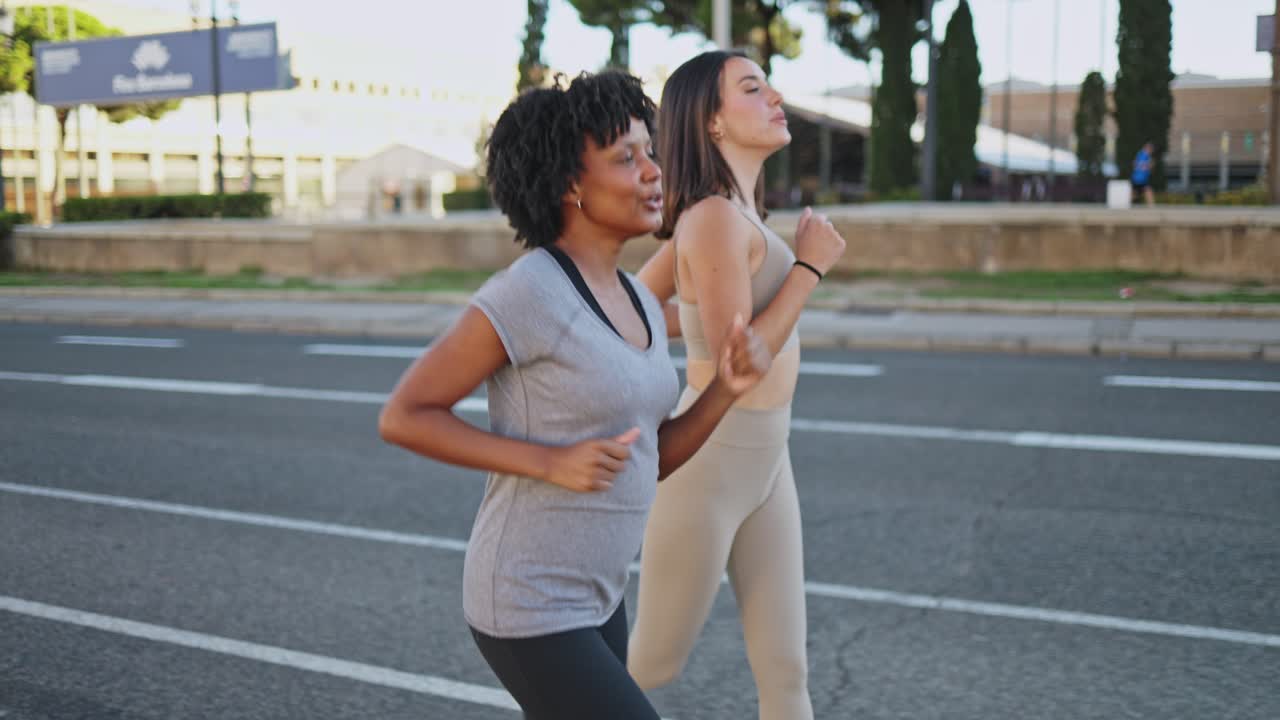 Due donne felici che corrono insieme su una strada cittadina