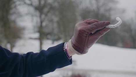 hand showcasing a clear aligner for teeth regulation, winter day, close up shallow depth of field