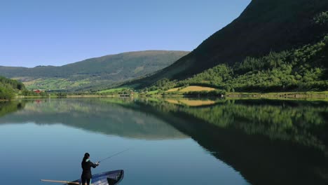 woman on the boat catches a fish on spinning in norway.