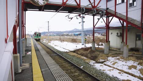 japanese train departs rural station in yamagata prefecture, tohoku region