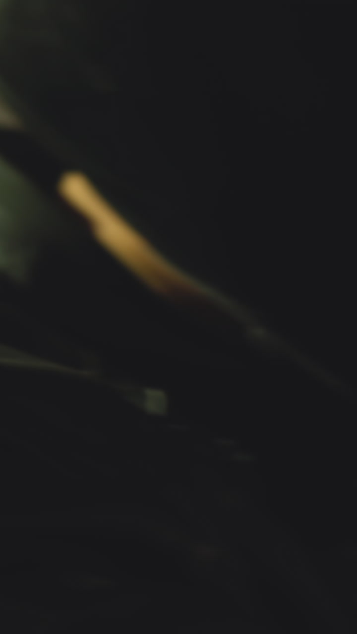 Armed man in black moto suit helmet prowls holding powerful handgun about empty room in abandoned building extreme close view slow motion