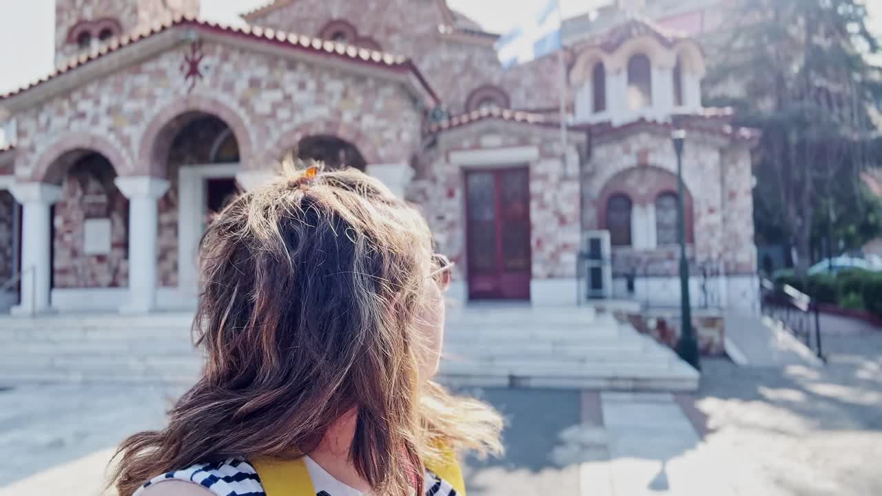 Donna turista felice che si fa un selfie in una chiesa ortodossa greca