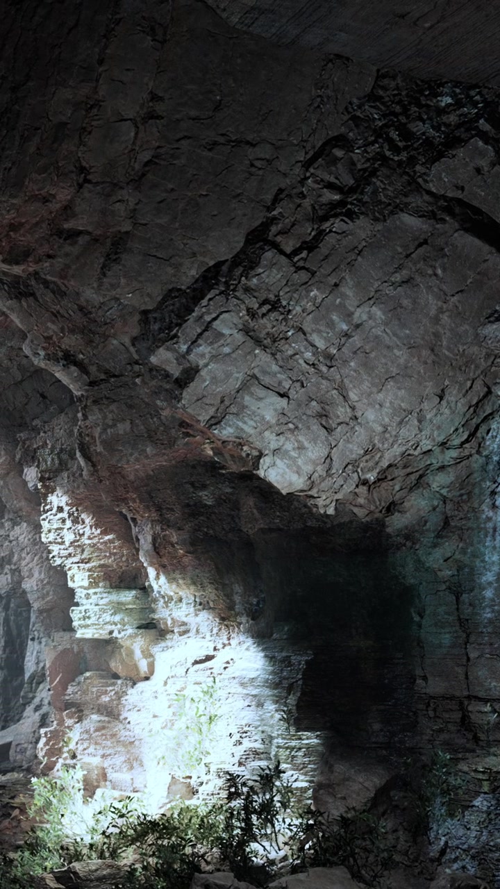 Esplorazione di una grotta con rocce e luce in un ambiente buio.