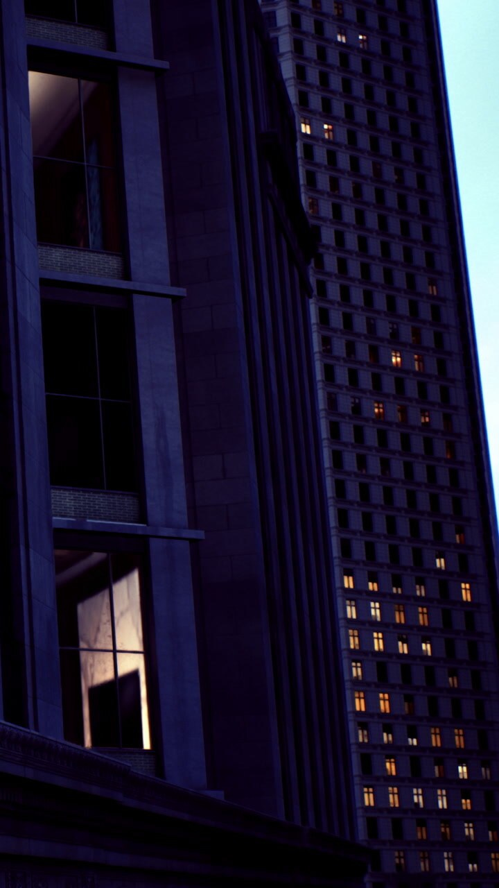 City buildings at dusk with lit windows and dark sky