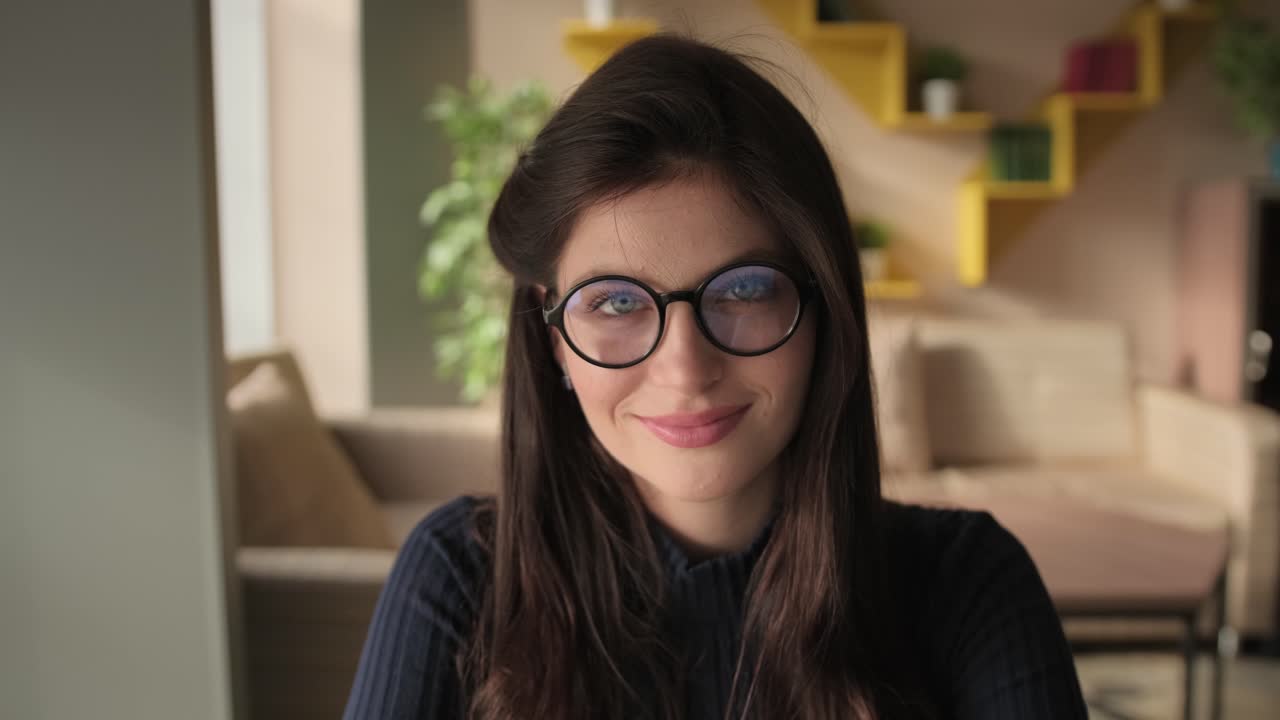 Donna con gli occhiali che sorride in soggiorno