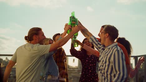 people toasting with drinks in rooftop terrace at sunset